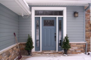 Close-up view of home during wintertime with slate blue front door.