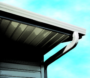 Home's roofline with white seamless gutters. Blue skies in background